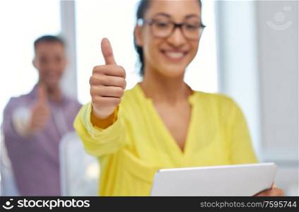 gesture and people concept - close up of happy young woman with tablet pc computer showing thumbs up. happy young woman with tablet pc showing thumbs up
