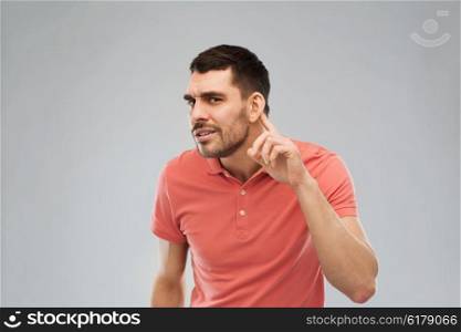 gesture and people concept - latin man having hearing problem listening to something. man having hearing problem listening to something