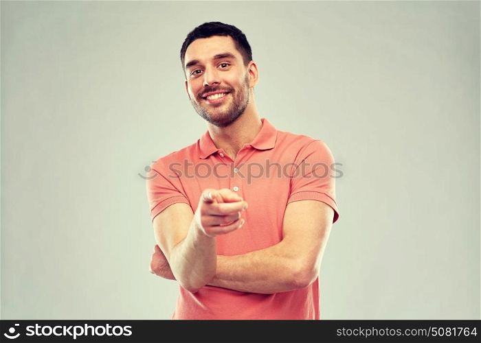gesture and people concept - man pointing finger to you over gray background. man pointing finger to you over gray background