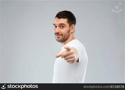gesture and people concept - man pointing finger to you over gray background. man pointing finger to you over gray background