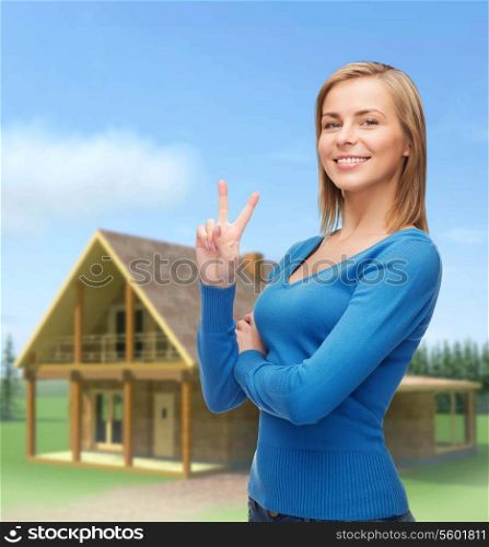 gesture and people concept - smiling teenage girl showing v-sign with hand