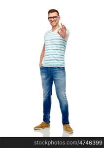 gesture and people concept - smiling young man in eyeglasses showing ok hand sign over white. young man in eyeglasses showing ok hand sign