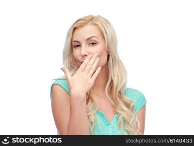 gesture and people concept - smiling young woman or teenage girl covering her mouth with hands. smiling young woman or teen girl covering mouth