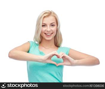 gesture and people concept - smiling young woman or teenage girl showing heart shape made of fingers. happy woman or teen girl showing heart shape sigh
