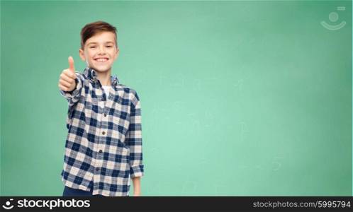 gesture, childhood, school, education and people concept - smiling student boy in checkered shirt and jeans showing thumbs up over green school chalk board background
