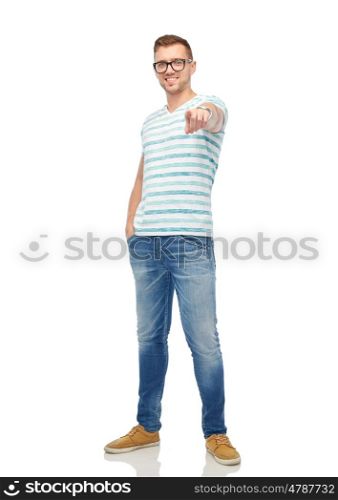 gesture, choice and people concept - happy smiling young man in eyeglasses pointing finger to you over white