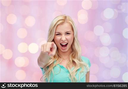 gesture, emotions, expressions and people concept - happy smiling young woman or teenage girl pointing finger to you over pink holidays lights background