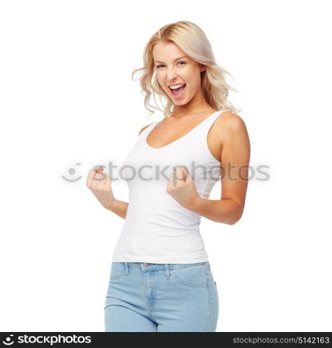 gesture, expressions and people concept - happy smiling young woman in white top and jeans doing fist pump. happy young woman doing fist pump gesture