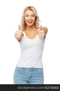gesture, expressions and people concept - happy smiling young woman in white top and jeans showing thumbs up. happy young woman showing thumbs up