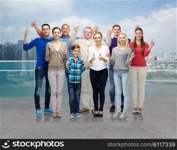gesture, family, generation and people concept - group of smiling men, women and boy showing thumbs up over singapore city waterside background