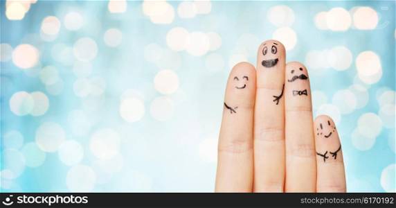 gesture, family, people and body parts concept - close up of two hands showing fingers with smiley faces over blue holidays lights background