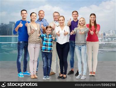 gesture, family, travel, generation and people concept - group of smiling men and women showing thumbs up over singapore city background