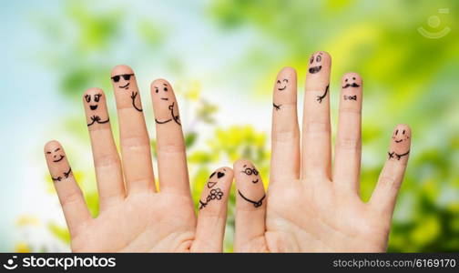 gesture, family, wedding, people and body parts concept - close up of two hands showing fingers with smiley faces over natural green herbal background