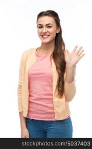 gesture, fashion, portrait and people concept - happy smiling young woman in cardigan waving hand over white. happy smiling young woman waving hand over white