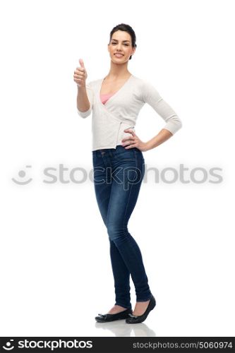 gesture, fashion, portrait and people concept - happy smiling young woman in cardigan and jeans showing thumbs up over white. happy smiling young woman showing thumbs up