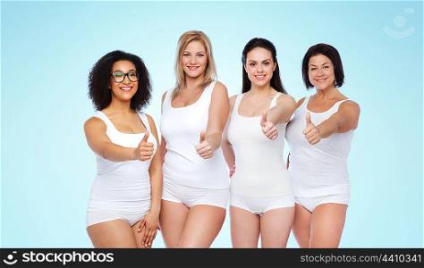 gesture, friendship, beauty, body positive and people concept - group of happy different women in white underwear showing thumbs up over blue background