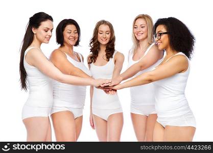 gesture, friendship, beauty, body positive and people concept - group of happy different women in white underwear holding hands together on top