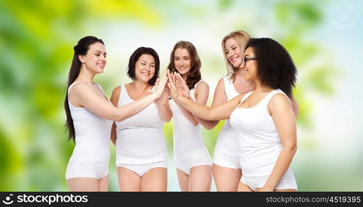 gesture, friendship, beauty, body positive and people concept - group of happy different women in white underwear making high five over green natural background