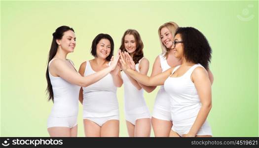 gesture, friendship, beauty, body positive and people concept - group of happy different women in white underwear making high five over green natural background