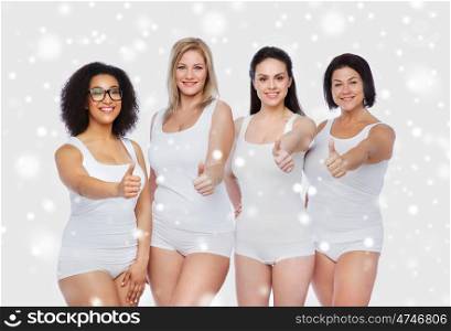 gesture, friendship, beauty, body positive and people concept - group of happy different women in white underwear showing thumbs up over snow