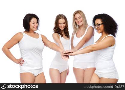 gesture, friendship, beauty, body positive and people concept - group of happy different women in white underwear holding hands together on top