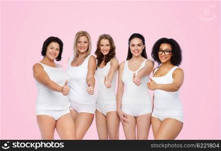 gesture, friendship, beauty, body positive and people concept - group of happy different women in white underwear showing thumbs up over pink background