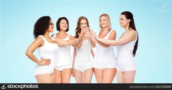 gesture, friendship, beauty, body positive and people concept - group of happy different women in white underwear making high five over blue background