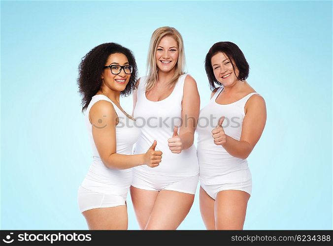 gesture, friendship, beauty, body positive and people concept - group of happy plus size women in white underwear showing thumbs up over blue background