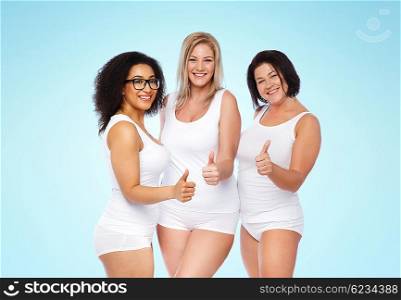 gesture, friendship, beauty, body positive and people concept - group of happy plus size women in white underwear showing thumbs up over blue background