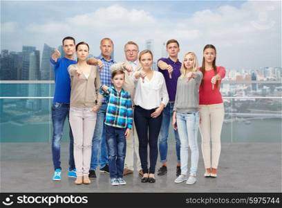 gesture, gender, generation and people concept - happy family giving thumbs down over singapore city waterside background