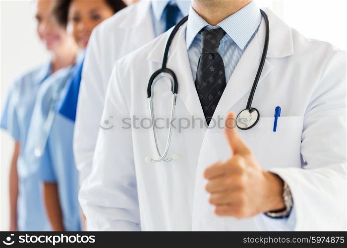 gesture, health care, people and medicine concept - close up of happy doctor showing thumbs up