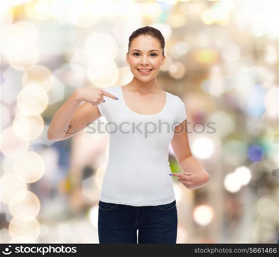 gesture, holidays, advertising and concept - smiling young woman in blank white t-shirt pointing fingers on herself over sparkling background