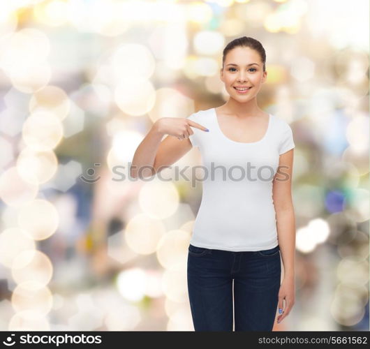 gesture, holidays, advertising and concept - smiling young woman in blank white t-shirt pointing finger on herself over sparkling background