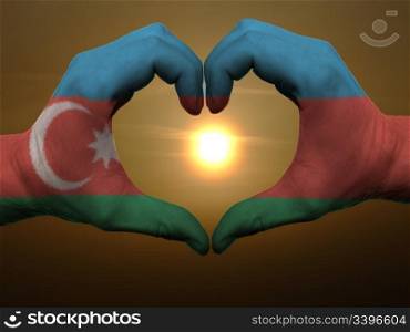 Gesture made by azerbaijan flag colored hands showing symbol of heart and love during sunrise