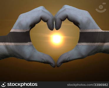 Gesture made by botswana flag colored hands showing symbol of heart and love during sunrise