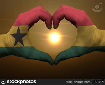 Gesture made by ghana flag colored hands showing symbol of heart and love during sunrise