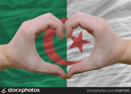 Gesture made by hands showing symbol of heart and love over Afghanistan flag