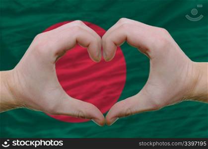 Gesture made by hands showing symbol of heart and love over bangladesh flag