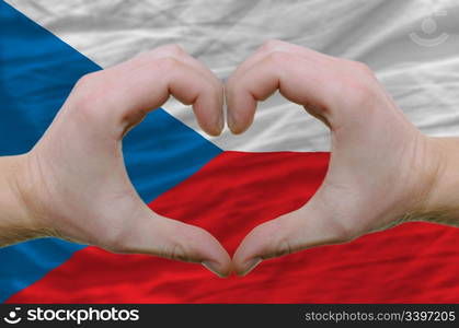 Gesture made by hands showing symbol of heart and love over czech flag