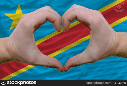 Gesture made by hands showing symbol of heart and love over flag of congo