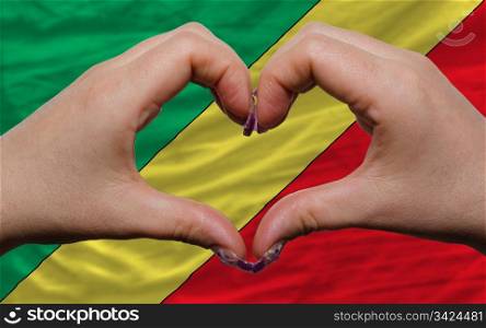 Gesture made by hands showing symbol of heart and love over flag of congo