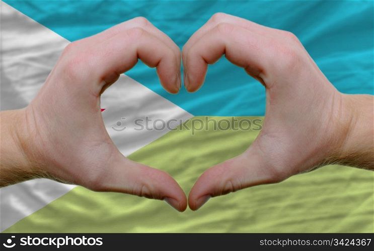Gesture made by hands showing symbol of heart and love over flag of djibuti