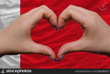 Gesture made by hands showing symbol of heart and love over national bahrain flag