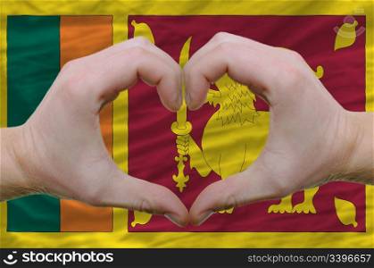 Gesture made by hands showing symbol of heart and love over srilanka