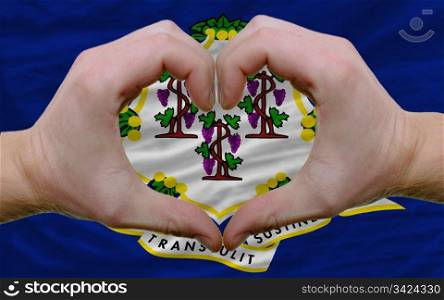 Gesture made by hands showing symbol of heart and love over us state flag of connecticut
