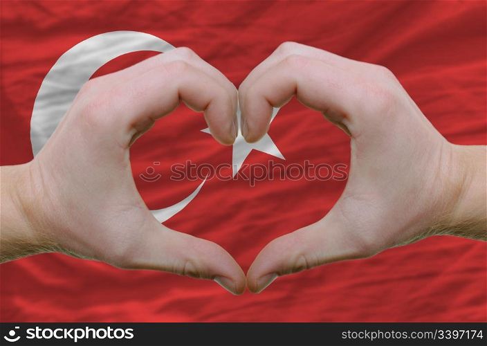 Gesture made by hands showing symbol of heart and love overturkey flag