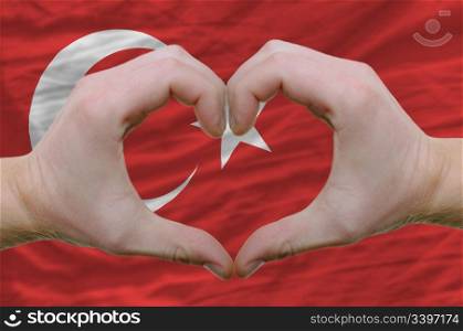 Gesture made by hands showing symbol of heart and love overturkey flag