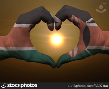 Gesture made by kenya flag colored hands showing symbol of heart and love during sunrise