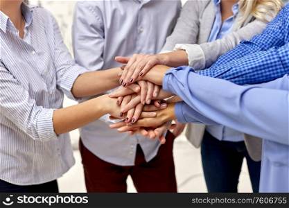 gesture, people and teamwork concept - close up of business team, friends or students stacking hands. close up of people stacking hands