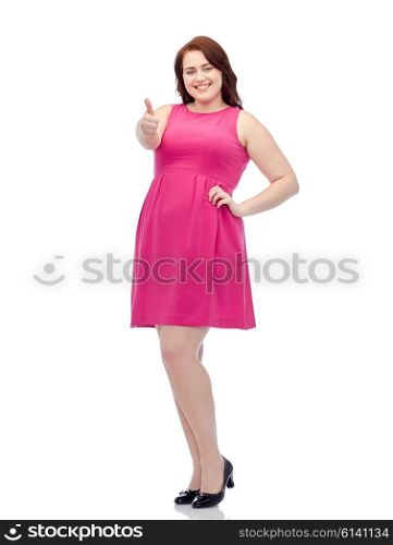 gesture, portrait and people concept - smiling happy young plus size woman posing in pink dress showing thumbs up